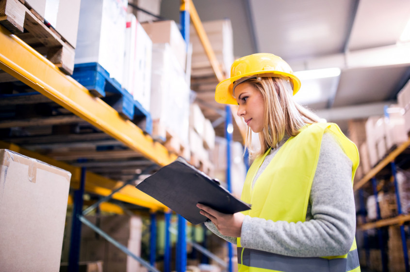 Woman warehouse worker with clipboard.